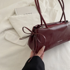 Sac à bandoulière bordeaux minimaliste avec détail nœud et imprimé texte tendance