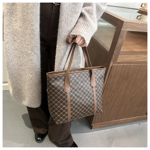 Close-up of vintage check pattern tote bag with leather handles shown in lifestyle setting