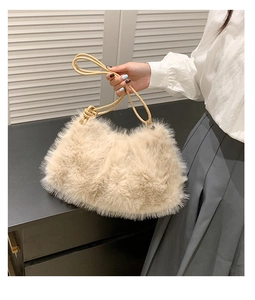 Detail view of the soft beige faux fur texture and slim leather strap of this plush tote bag