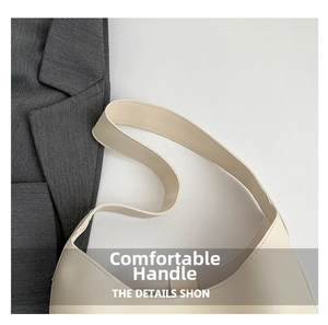 Détail de la poignée en cuir beige minimaliste et des coutures sur un sac vintage