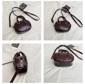 Detailed view of dark brown PU leather handbag with embossed logo and gold hardware