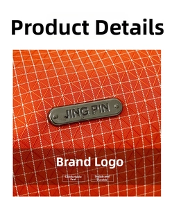 Détail du tissu en nylon à carreaux orange vif avec une étiquette métallique de marque