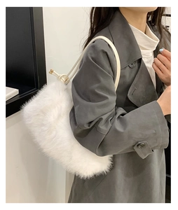 Detail of soft white plush tote bag with knotted cord strap and metal buckle accent