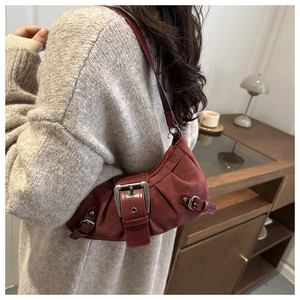 Dettaglio borsa vintage bordeaux con fibbia in metallo e silhouette plissettata