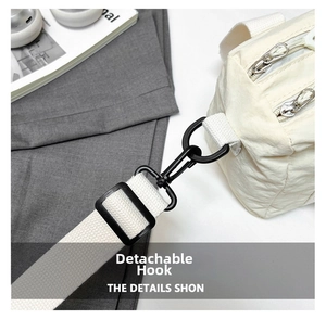 Detail view of durable black plastic swivel hook and woven strap on canvas bag