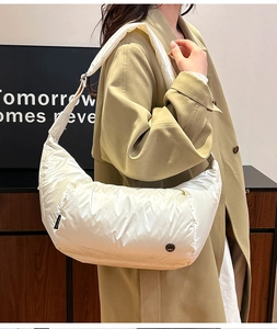 Dettaglio borsa a tracolla trapuntata beige con etichetta EST 2020 e tessuto nylon