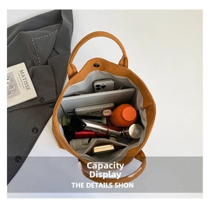 Internal view of large orange suede tote bag showing tablet and zipper pocket storage