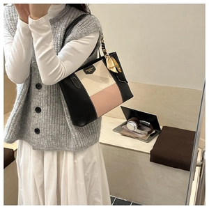 Detail of color-block tote bag with silk scarf handle and matte leather texture
