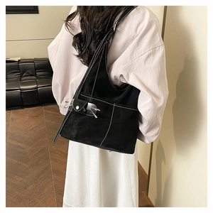 Close-up of black canvas tote bag featuring white contrast stitching and eyewear pocket