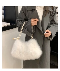 Detail of white faux fur shoulder bag featuring soft plush texture and cream rope strap