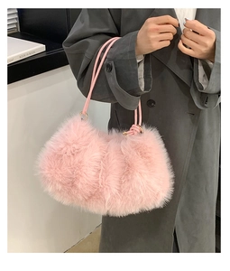 Close-up of soft pink faux fur texture and metal ring handle attachment on a plush tote bag