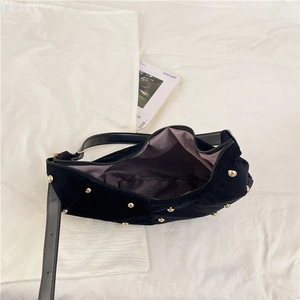 Retro black suede hobo bag with gold rivets shown from a top-down view for capacity