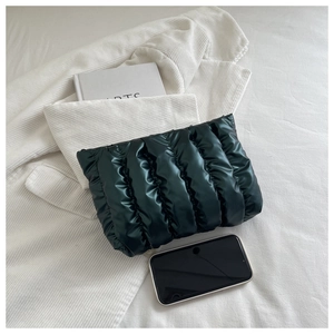 Detailansicht der dunkelgrünen Stepp-Clutch aus Nylon mit glänzender Faltenstruktur