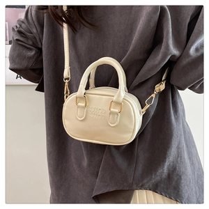 Detail of the embossed logo and premium leather texture on an off-white mini Boston bag