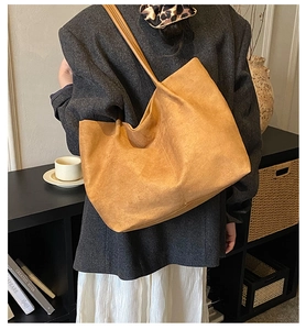 Vista dettagliata a spalla di una borsa tote grande in camoscio zenzero con trama morbida