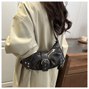 Detail of vintage black leather crescent shoulder bag with silver buckle and rivets