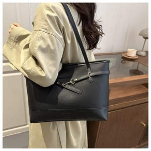 Detail of a black large capacity tote bag with lychee texture leather and metal buckle