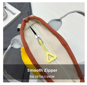 Detailed close-up of smooth silver zipper and colorful canvas stitching on outdoor bag