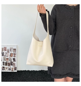 Détail du grand sac cabas beige minimaliste avec lettrage doré et large bandoulière