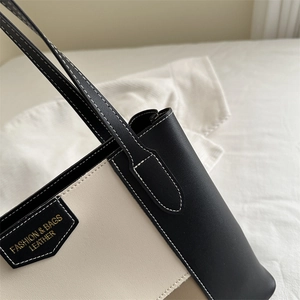 Minimalist color-block tote bag in black and beige leather with contrast stitching detail