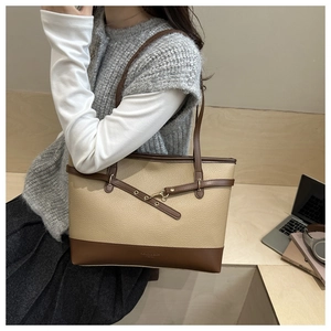 Litchi texture detail on large beige and brown tote bag styled in a modern office scene