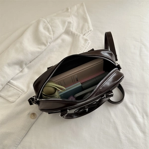 Deep brown faux leather tote bag with large capacity showing interior storage space