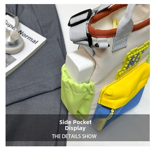 Detail of color-block canvas bag side pocket holding a power bank for storage
