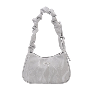 Light gray pleated shoulder bag with silver bow accent and curved crescent moon silhouette