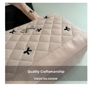 Detail of pink quilted tote bag with black bow embroidery and silver metal bow