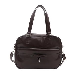 Minimalist chocolate brown leather shoulder bag with bow and heart charm on white background