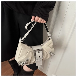 Close-up of vintage beige pleated handbag with large metal buckle and textured fabric