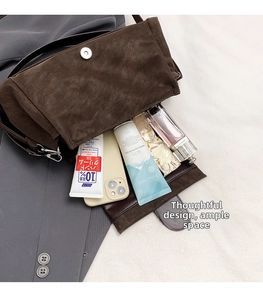 Gros plan de l'intérieur d'un sac bandoulière en daim marron avec grand espace de rangement