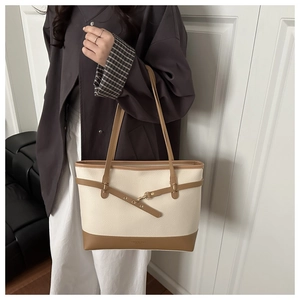 Detail of the litchi texture PU leather and gold buckle on the two-tone tote bag