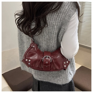 Detail showing vintage burgundy crescent bag with silver buckle and stud rivets