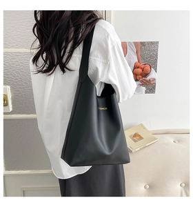 Gros plan du fourre-tout noir mat avec lettrage Fashion doré et large bandoulière épaule