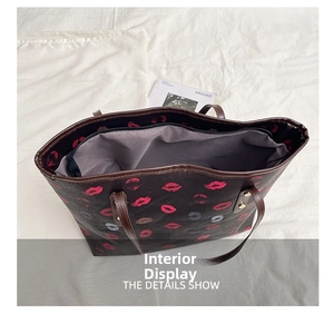 Detail view of large tote bag interior with zipper closure and red lip print pattern