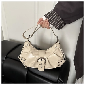 Detail of cream pleated motorcycle bag featuring silver rivets and metal buckle detail