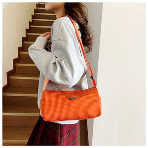Détail de la sacoche en nylon à carreaux orange avec bandoulière réglable et logo