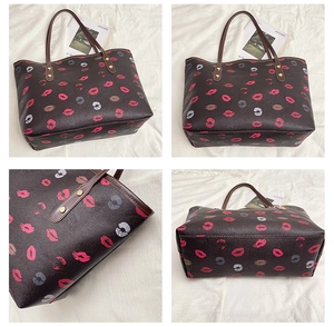 Detail of large brown tote bag showing floral lip print patterns and reinforced rivets