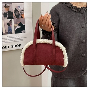 Detail of burgundy suede moon bag with faux fur trim and adjustable shoulder strap
