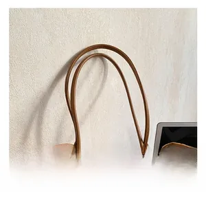 Dettaglio ravvicinato della borsa tote in pelle scamosciata marrone con manici in pelle