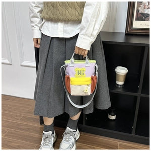 Detail of multi-color canvas water bottle bag with pixel M logo and crossbody strap
