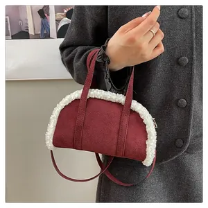 Detail of burgundy suede handbag with white faux shearling trim and zip closure