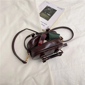 Glossy dark brown mini shoulder bag with gold hardware and interior storage space