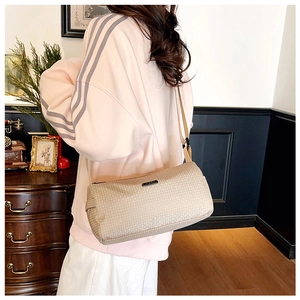 Détail du sac cylindre en nylon champagne avec motifs géométriques et bandoulière