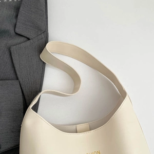 Sac fourre-tout minimaliste en cuir blanc crème avec logo doré et large bandoulière femme