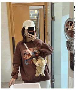 Close-up of Lion King print sweatshirt with a 3D plush bear crossbody bag accessory