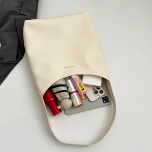 Sac fourre-tout crème minimaliste pour femmes montrant une grande capacité pour objets