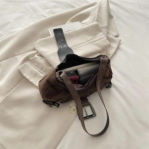 Brown faux suede underarm bag with decorative buckle and wide shoulder strap