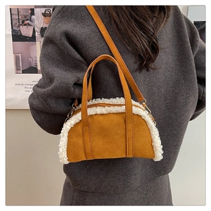 Detail view of brown suede handbag with white faux shearling trim and gold hardware